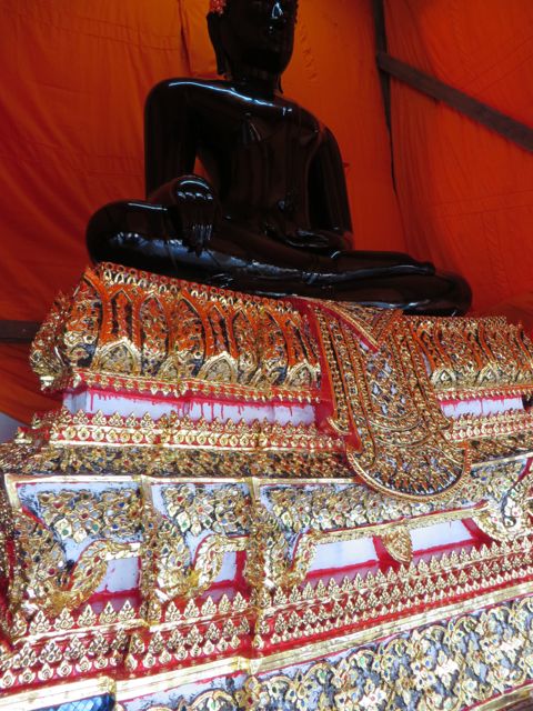 This buddha is covered in black wax or paint in order to receive his new building.