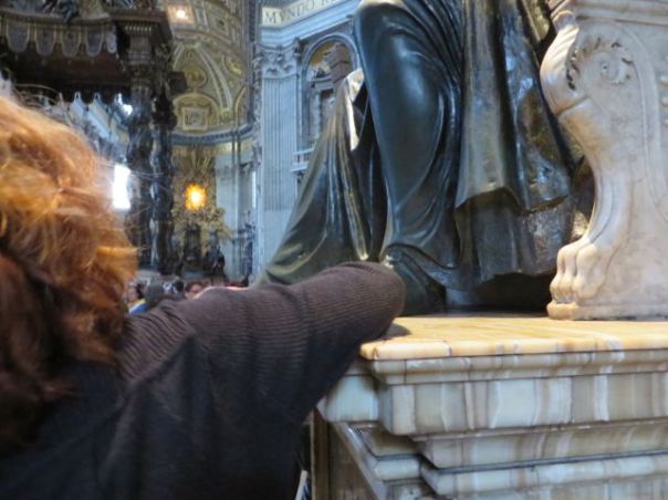 Kim rubbing this saint's foot for good luck.